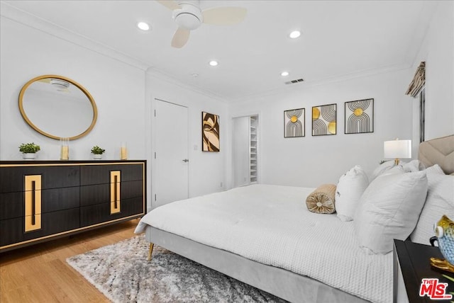 bedroom featuring crown molding, ceiling fan, and light hardwood / wood-style floors