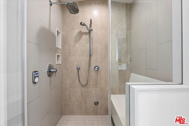 bathroom featuring tiled shower, tile patterned floors, and tile walls