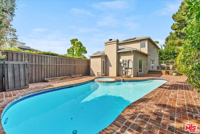 view of pool with a patio area and an in ground hot tub