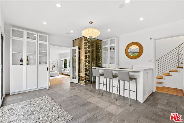 kitchen featuring white cabinetry, a kitchen breakfast bar, and hanging light fixtures