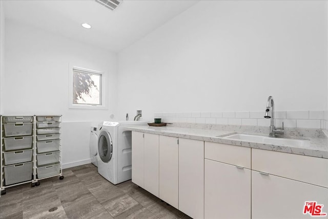 laundry room featuring sink, cabinets, and washer and dryer