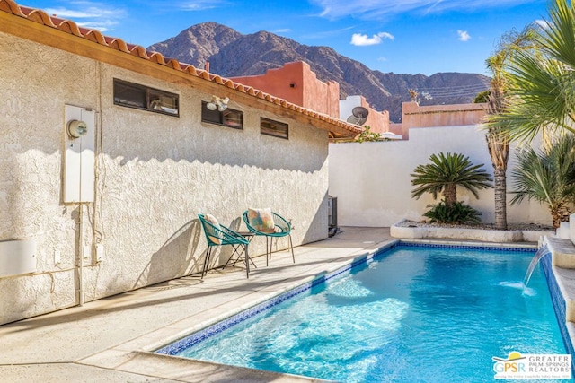 view of pool with a mountain view, a patio area, and pool water feature