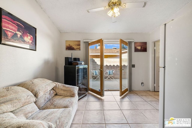 tiled living room with a textured ceiling and ceiling fan