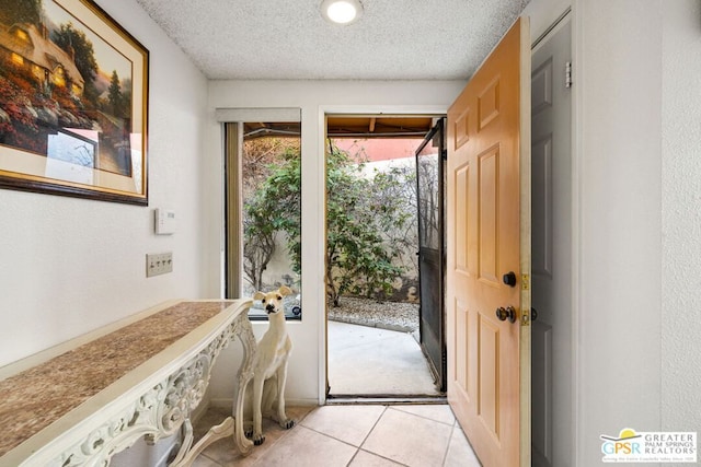 doorway with light tile patterned flooring and a textured ceiling