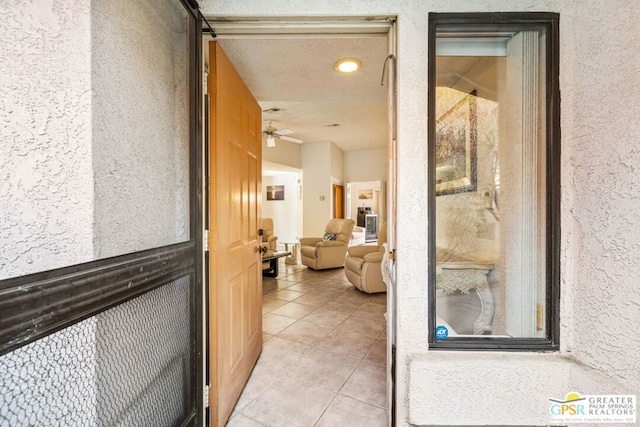 hallway with light tile patterned flooring and a textured ceiling