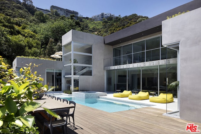 view of swimming pool featuring an in ground hot tub and a deck