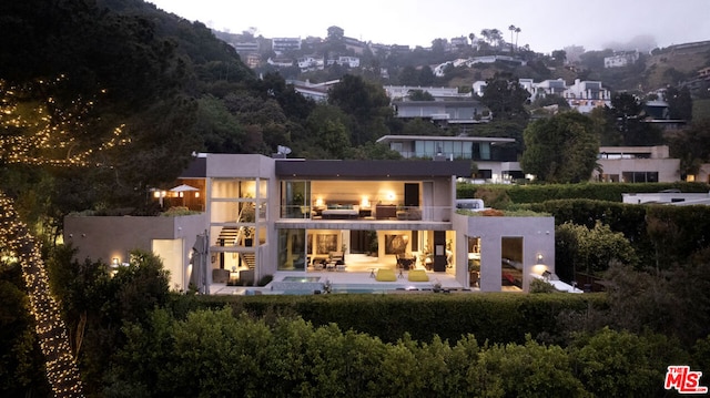 back of property with an outdoor hangout area, a patio, and a balcony