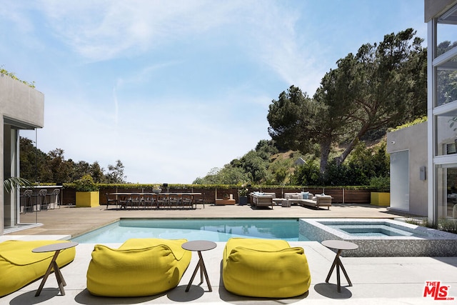 view of swimming pool with an outdoor living space, an in ground hot tub, and a patio