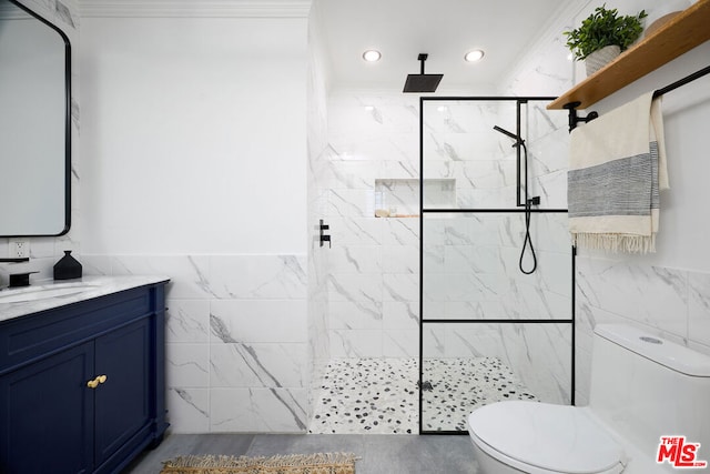 bathroom with a tile shower, tile walls, vanity, and toilet