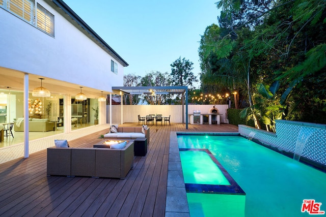 pool at dusk featuring a grill, outdoor lounge area, and a deck