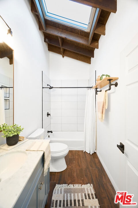 full bathroom with shower / bathtub combination with curtain, hardwood / wood-style floors, beam ceiling, vanity, and toilet