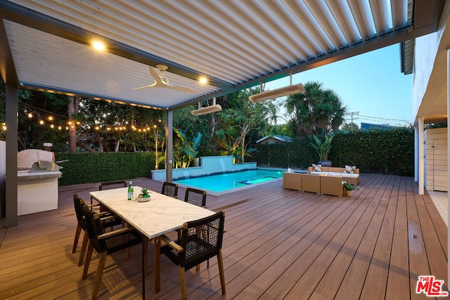 deck at dusk featuring ceiling fan, area for grilling, and a fenced in pool