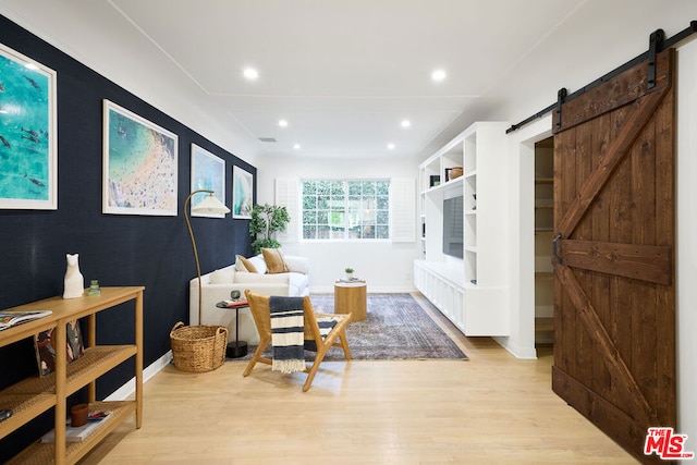 interior space with light hardwood / wood-style floors and a barn door