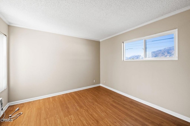 unfurnished room featuring crown molding, wood-type flooring, and a textured ceiling