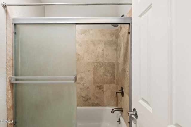 bathroom featuring combined bath / shower with glass door