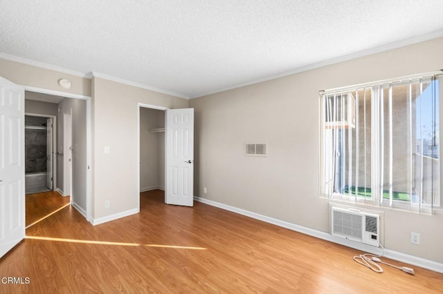 unfurnished bedroom with crown molding, hardwood / wood-style flooring, a closet, and a textured ceiling