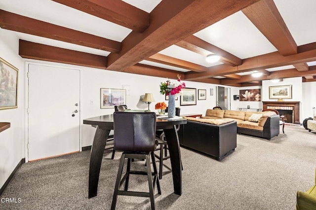 dining room featuring carpet, a fireplace, and beam ceiling