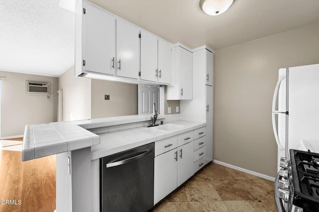 kitchen with tile countertops, white cabinetry, sink, kitchen peninsula, and stainless steel appliances