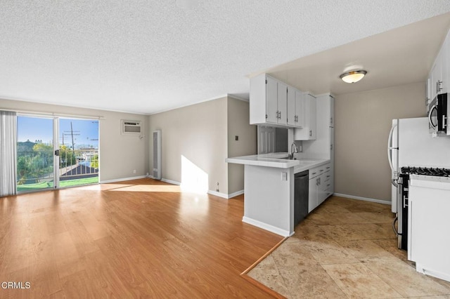 kitchen with sink, appliances with stainless steel finishes, a textured ceiling, white cabinets, and kitchen peninsula