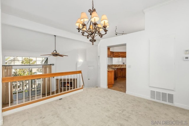 spare room featuring beamed ceiling, light colored carpet, and ceiling fan with notable chandelier