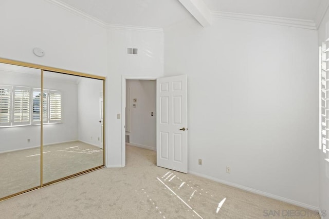 unfurnished bedroom featuring high vaulted ceiling, carpet flooring, ornamental molding, a closet, and beamed ceiling