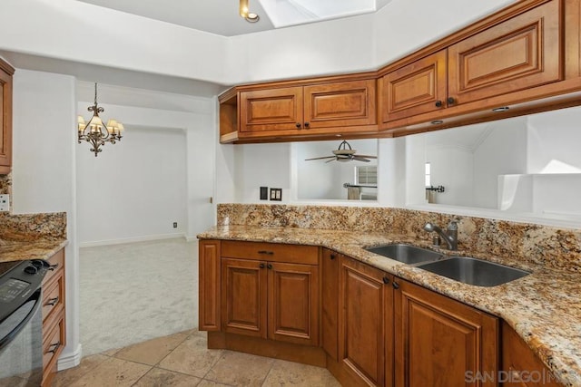 kitchen with light stone countertops, sink, range, and light carpet