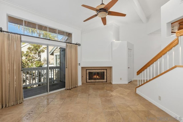 unfurnished living room featuring a tiled fireplace, ceiling fan, beamed ceiling, and a high ceiling