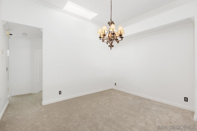 carpeted spare room featuring ornamental molding and a chandelier