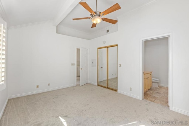 unfurnished bedroom with crown molding, ensuite bathroom, lofted ceiling with beams, and light carpet