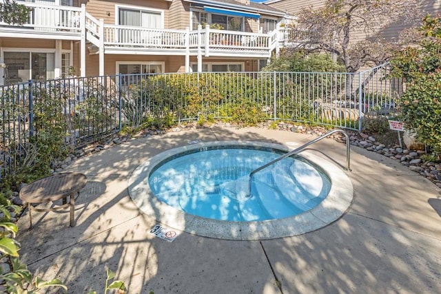 view of swimming pool with a hot tub