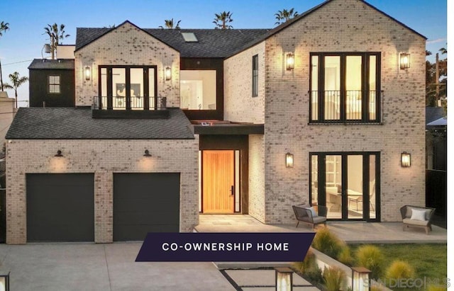 view of front of property featuring a garage and a balcony