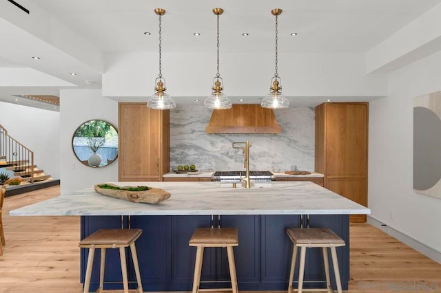 kitchen featuring pendant lighting, a large island, a breakfast bar area, and backsplash