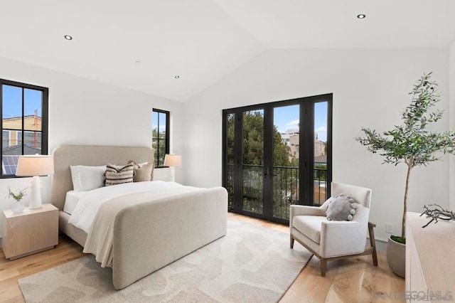 bedroom with lofted ceiling, access to exterior, french doors, and light wood-type flooring