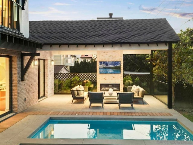 view of swimming pool featuring an outdoor living space with a fireplace and a patio area