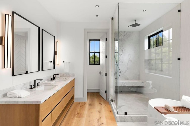 bathroom featuring vanity, an enclosed shower, hardwood / wood-style floors, and a healthy amount of sunlight