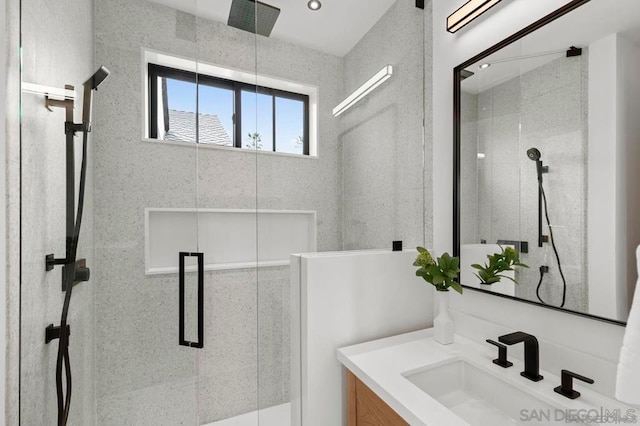 bathroom featuring vanity and a shower with door