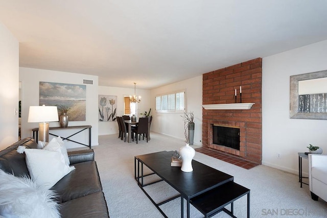 carpeted living room with a brick fireplace and a notable chandelier