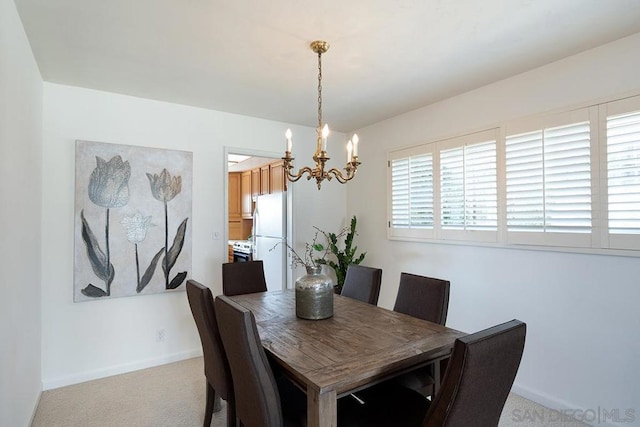 carpeted dining space featuring a chandelier