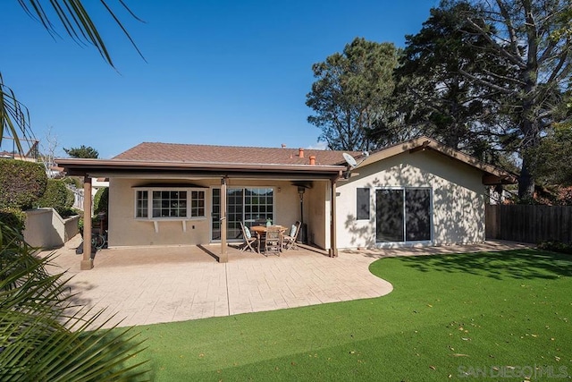 rear view of property featuring a yard and a patio area