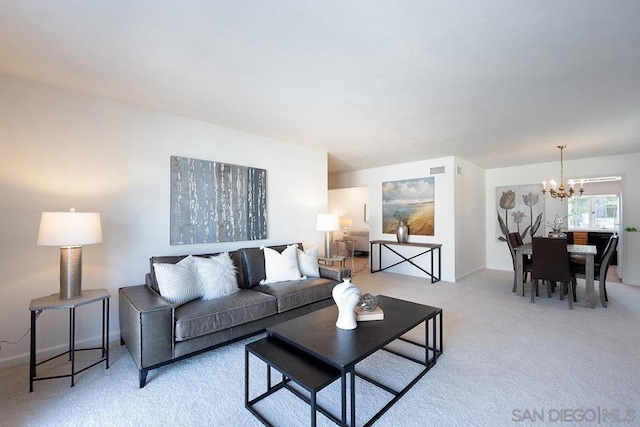 carpeted living room featuring an inviting chandelier