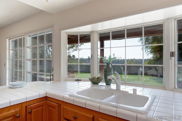 kitchen featuring tile countertops and sink