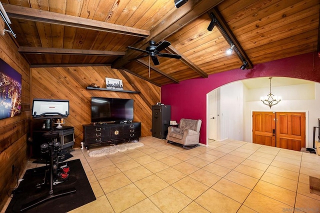 living room with rail lighting, vaulted ceiling with beams, wood ceiling, wooden walls, and ceiling fan with notable chandelier