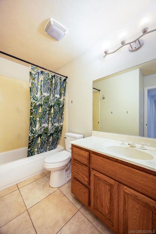 full bathroom with vanity, toilet, tile patterned floors, a textured ceiling, and shower / bath combo with shower curtain