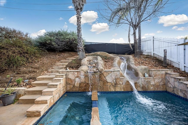 view of swimming pool with pool water feature