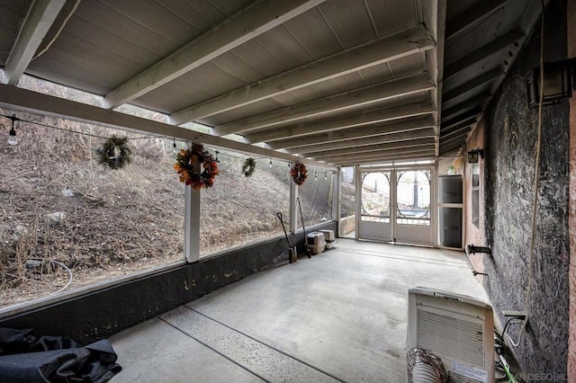 unfurnished sunroom with heating unit and beam ceiling