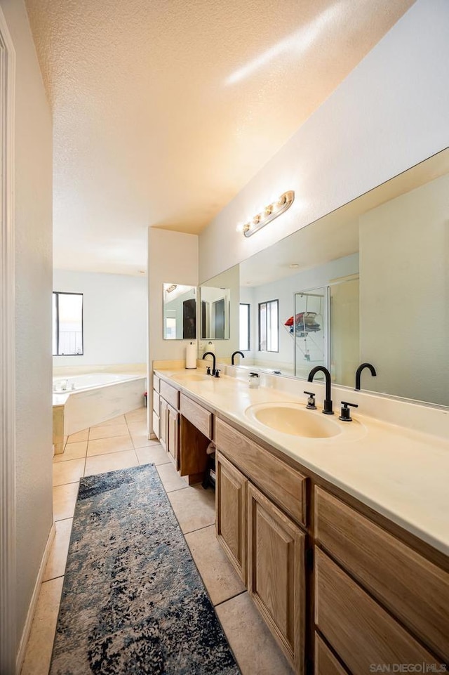 bathroom featuring vanity, tile patterned floors, shower with separate bathtub, and a textured ceiling