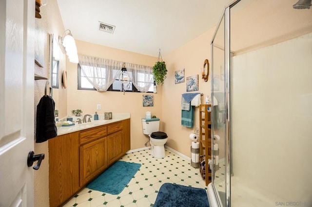 bathroom with a shower with door, vanity, and toilet