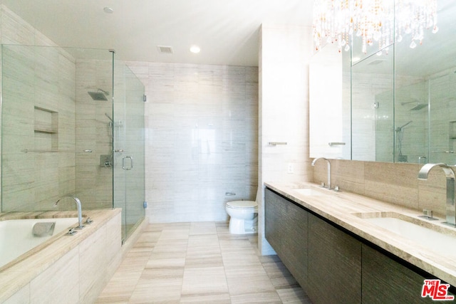 full bathroom featuring tile walls, separate shower and tub, vanity, decorative backsplash, and toilet