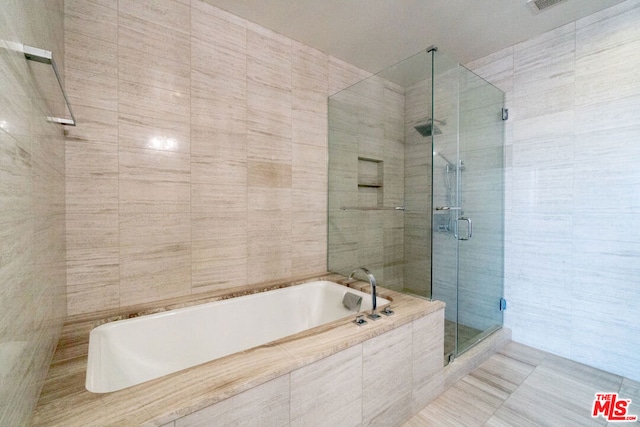 bathroom with tile walls and plus walk in shower