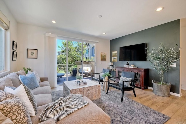 living room with a healthy amount of sunlight and light hardwood / wood-style flooring